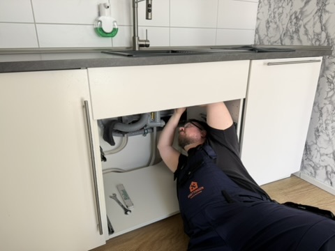 Arbeiten am Anschluss unter einer Küchenspüle